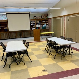 main meeting room in chestertown with chairs and tables and screen